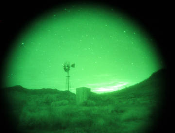 An image through night vision goggles showing a windmill.
